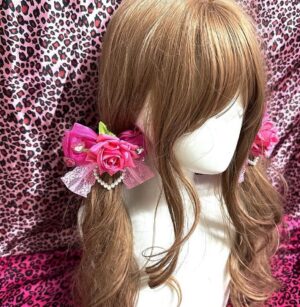 Deep rose red Hime Gyaru hair clip worn on mannequin with long brown wig showing mesh bow and heart pearl chain ornament detail on pink leopard print background