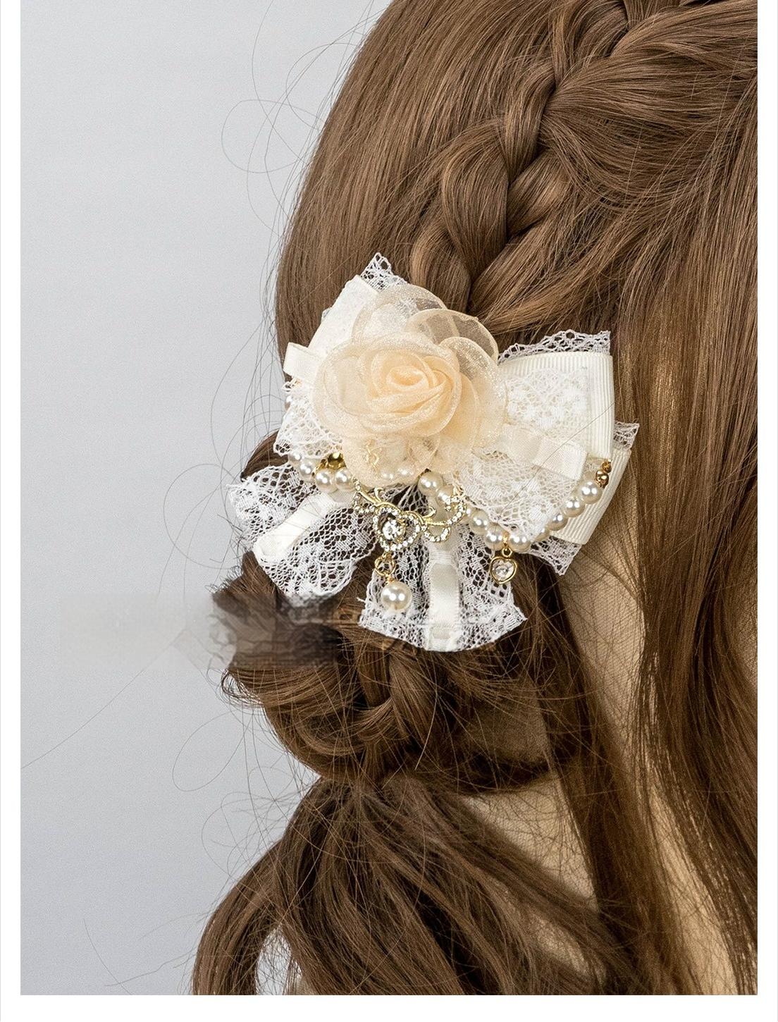 Close-up back view of beige rose hair clip with white lace bow pearl and metal ornament on braided hair