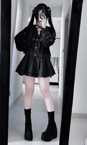 Full-length mirror selfie of black Jirai Kei cardigan set with pleated satin skirt, platform boots, and dramatic alternative aesthetic in home corridor