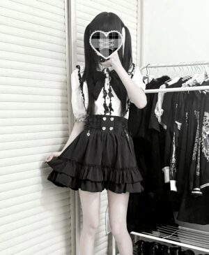 Black and white Jirai Kei two-piece blouse set with tiered ruffled skirt and heart bow brooch detail mirror selfie