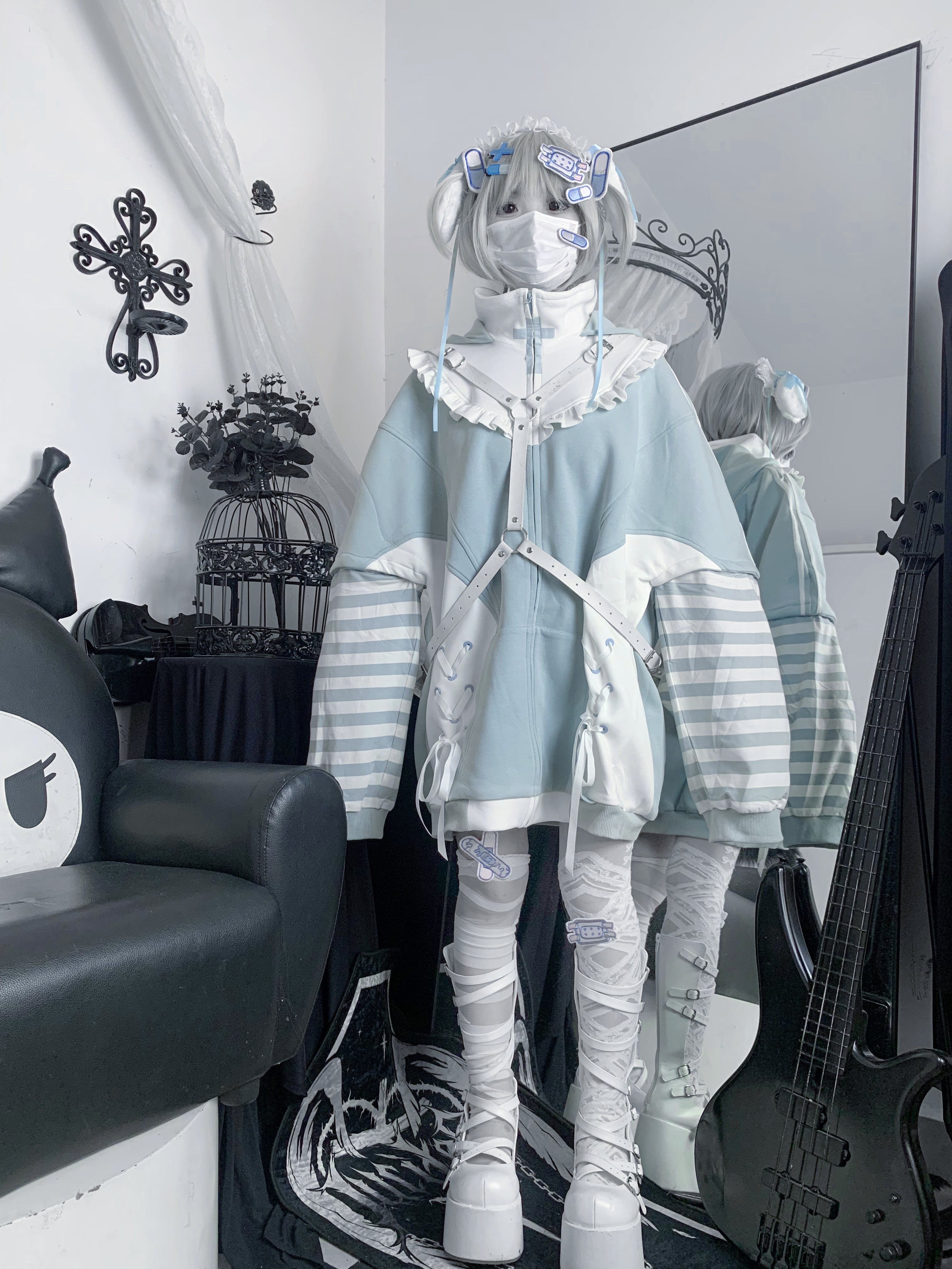 Full-body front view of blue gothic Tenshi Kaiwai lolita hoodie outfit with striped sleeves, cross body straps, and layered wrap leg socks on masked silver grey hair model