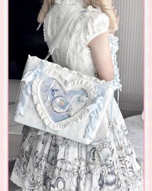 Heart-shaped itabag jirai kei shoulder bag rear three-quarter view with blonde model wearing vintage lolita dress light blue satin bows ruffled heart display window anime badges