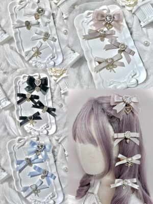 Assorted multicolor Jirai Kei bow hair clips collection top-down flat lay on decorative trays with lace backdrop showing multiple color variants and rhinestone embellishments