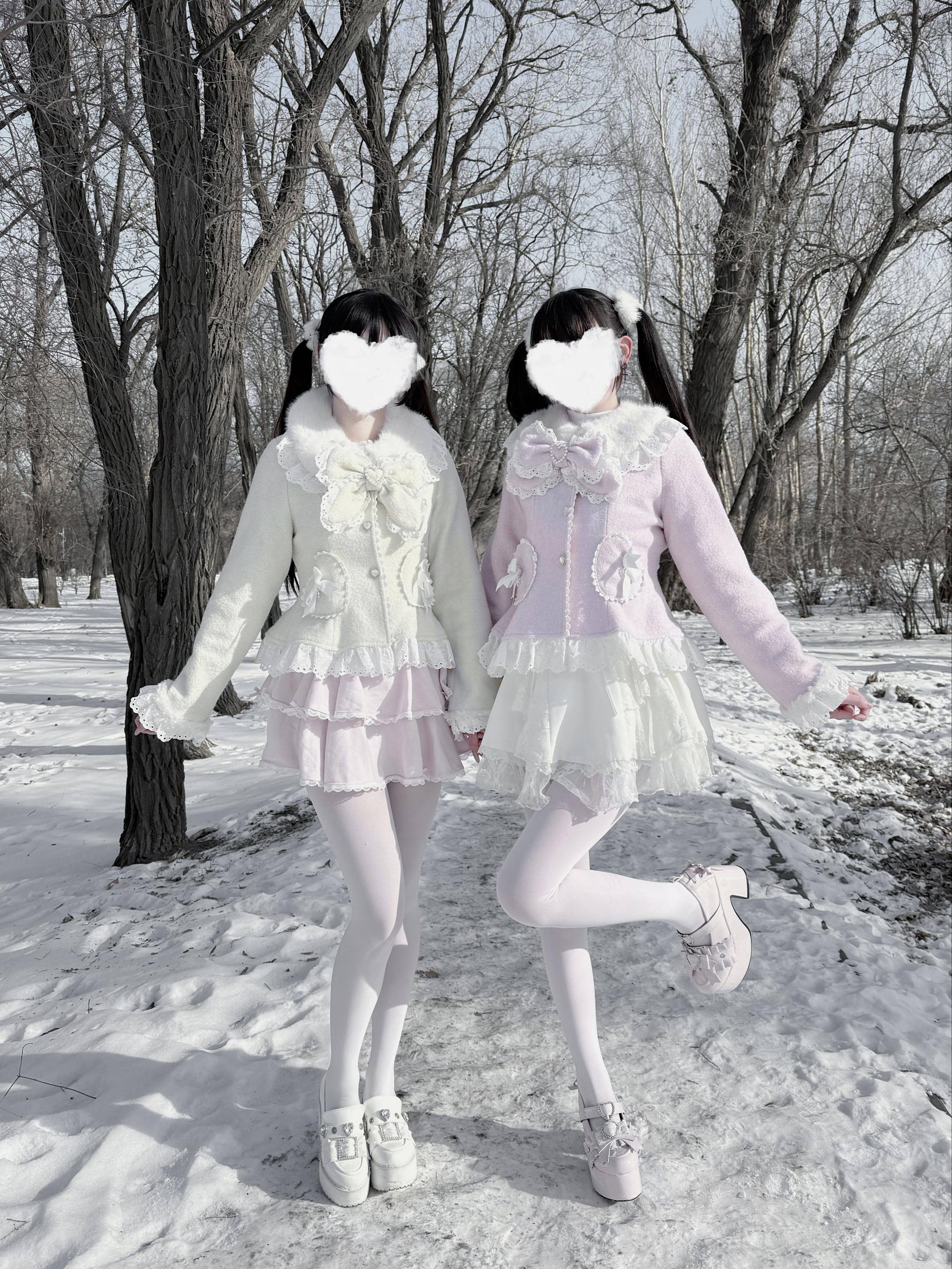 Sweet Jirai Kei Ryousangata coats on two models wearing matching pink and cream outfits with layered ruffle skirts, snowy outdoor park three-quarter angle photography