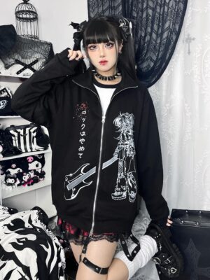 Oversized black Jirai Kei zip-up hoodie with white anime graphic and blue polka dot collar front medium shot on female goth model in rock-themed bedroom