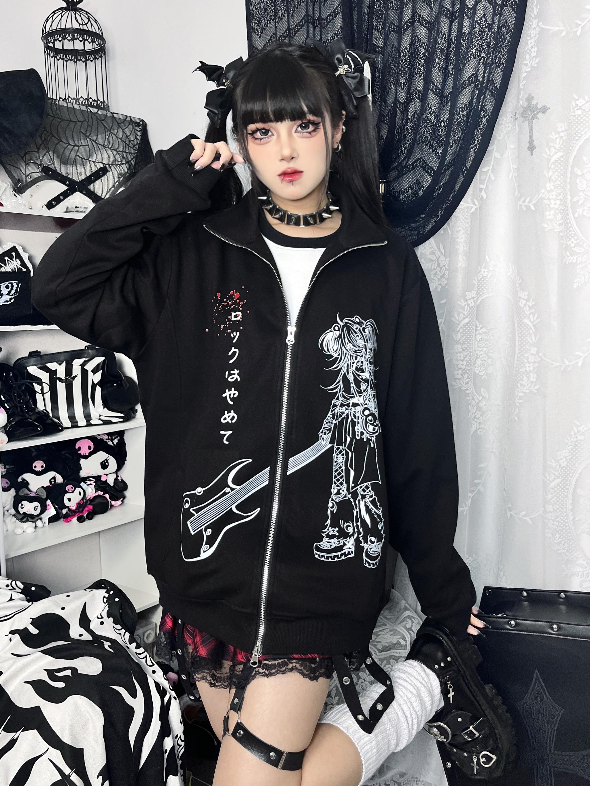 Oversized black Jirai Kei zip-up hoodie with white anime graphic and blue polka dot collar front medium shot on female goth model in rock-themed bedroom