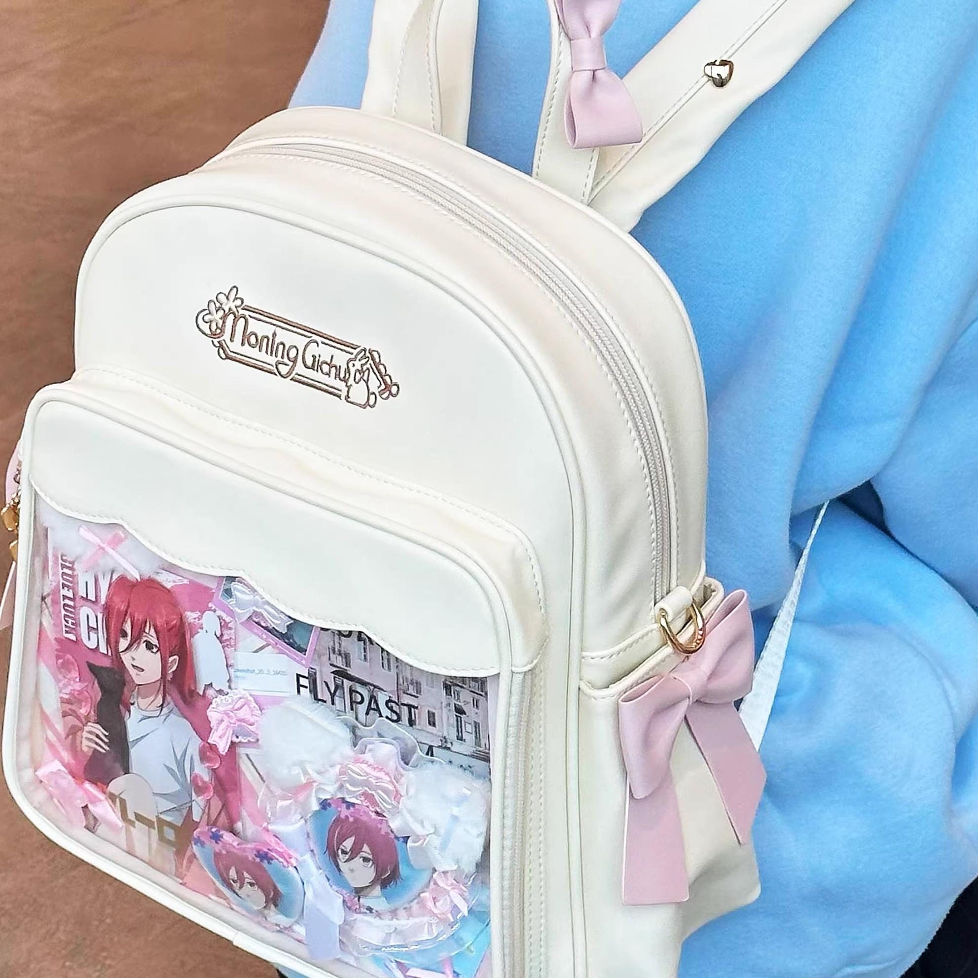 Kawaii anime itabag on human model showing embroidered vintage logo close-up smooth leather texture with side bow detail