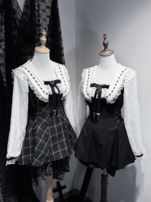 Two complete Jirai Kei two-piece outfits displayed on mannequins featuring solid black and plaid variants with lace collars and long-sleeve tops in dark studio setting