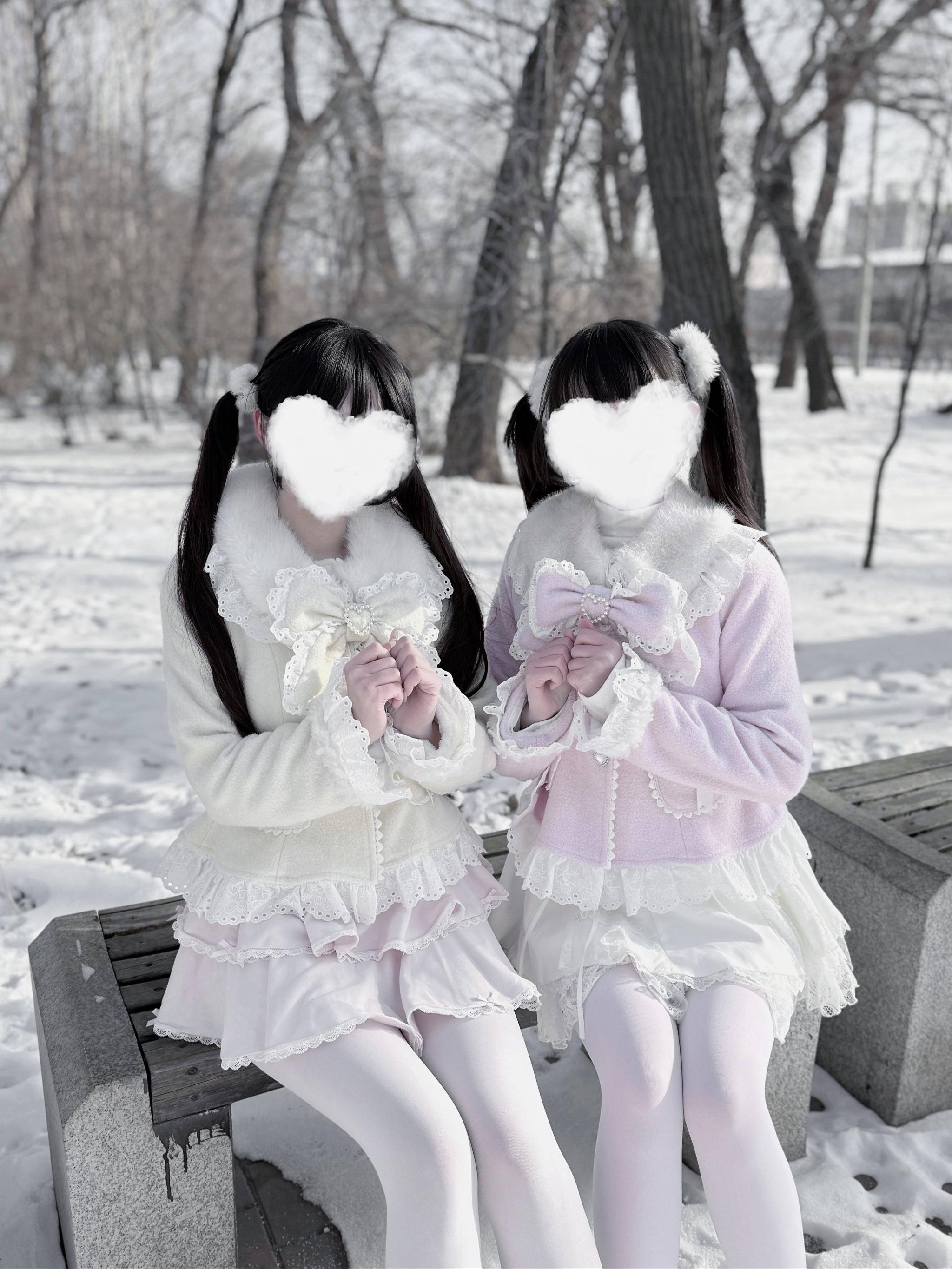 Sweet Jirai Kei Ryousangata coats on two models sitting on park bench wearing pink and cream matching styles with ruffle layered skirts, low angle front perspective