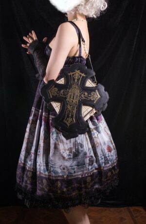 Gothic cross shoulder bag back view on model in dark printed tiered lolita dress with black leather base and gold religious embroidery pattern