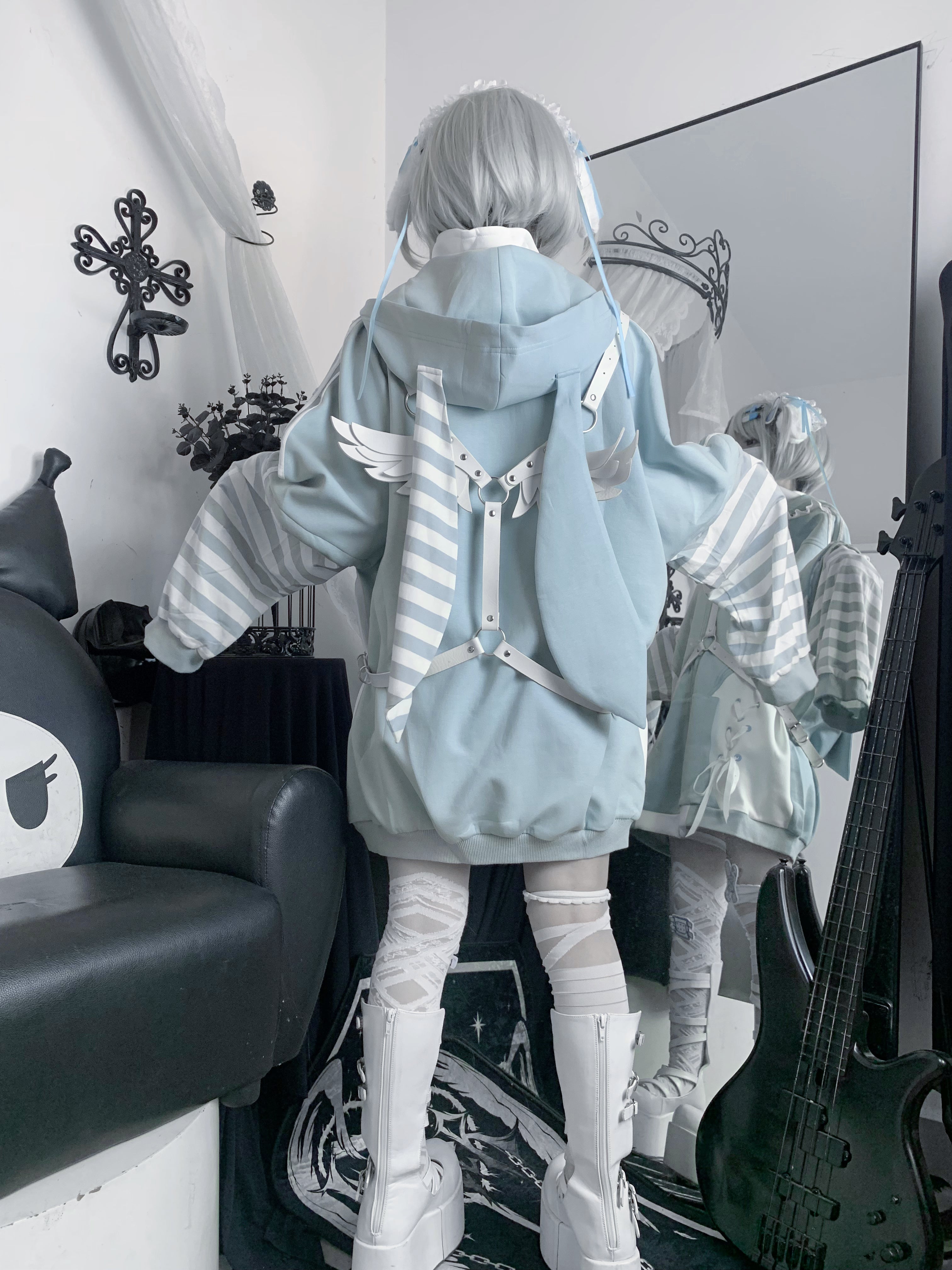 Mirror back shot of blue Tenshi Kaiwai bunny ear hoodie featuring wing and striped bunny ear back decoration, loose hood silhouette on silver grey hair model