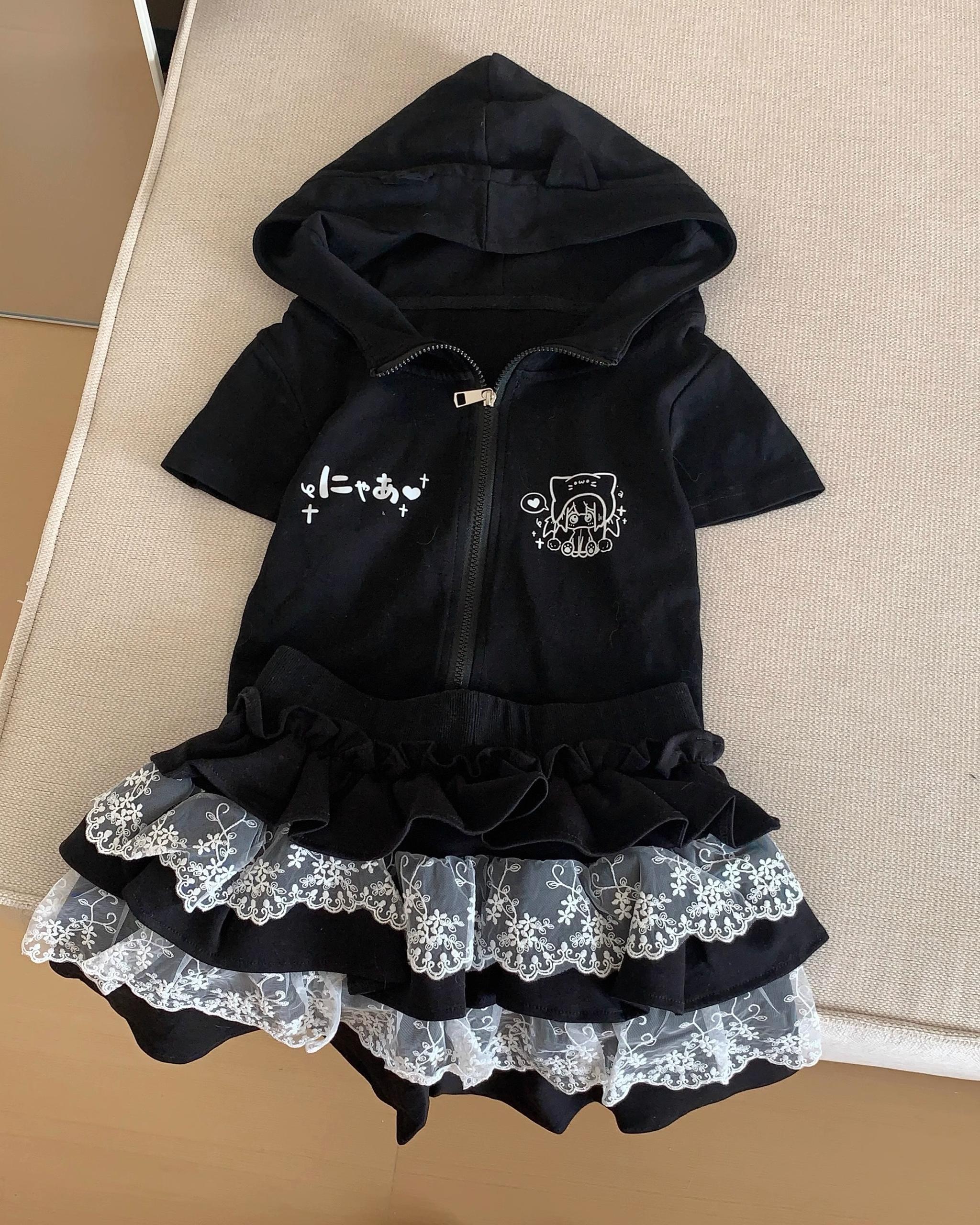 Black lace ruffle cake skirt flat lay display on beige cushion with matching bunny-ear zip-up hoodie top showing tiered hem detail from overhead view