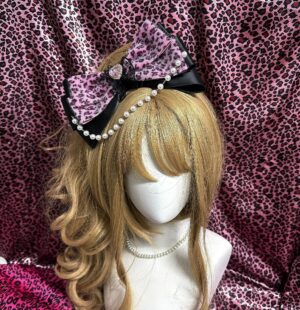 rose red pink leopard print bow hair clip on blonde mannequin three-quarter front view black satin trim heart gem sparkling rhinestone pearl chain details