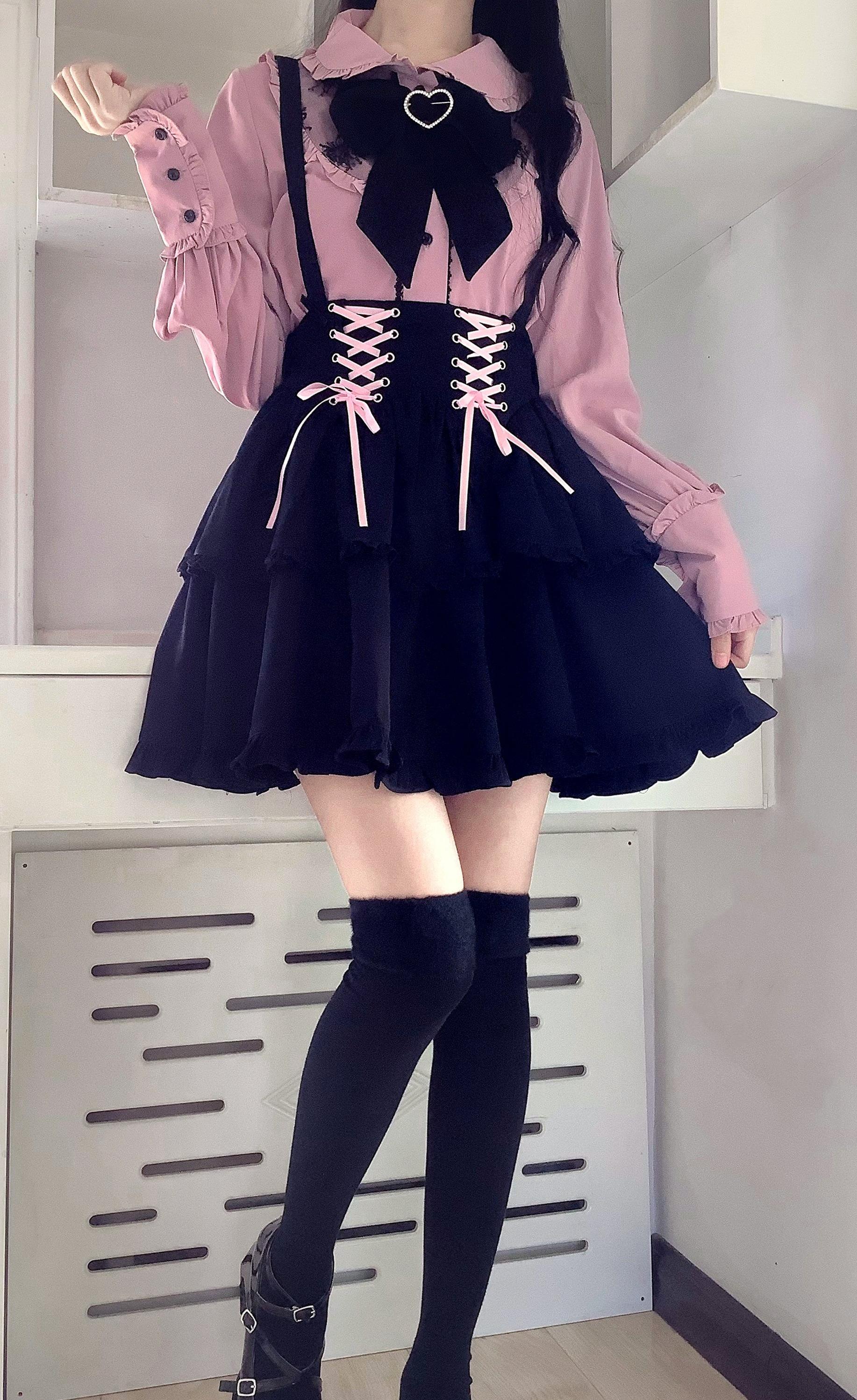 Side profile full-body Jirai Kei fashion shot with navy tiered skirt, long-sleeve dusty pink blouse, black bow tie, indoor shelf decor
