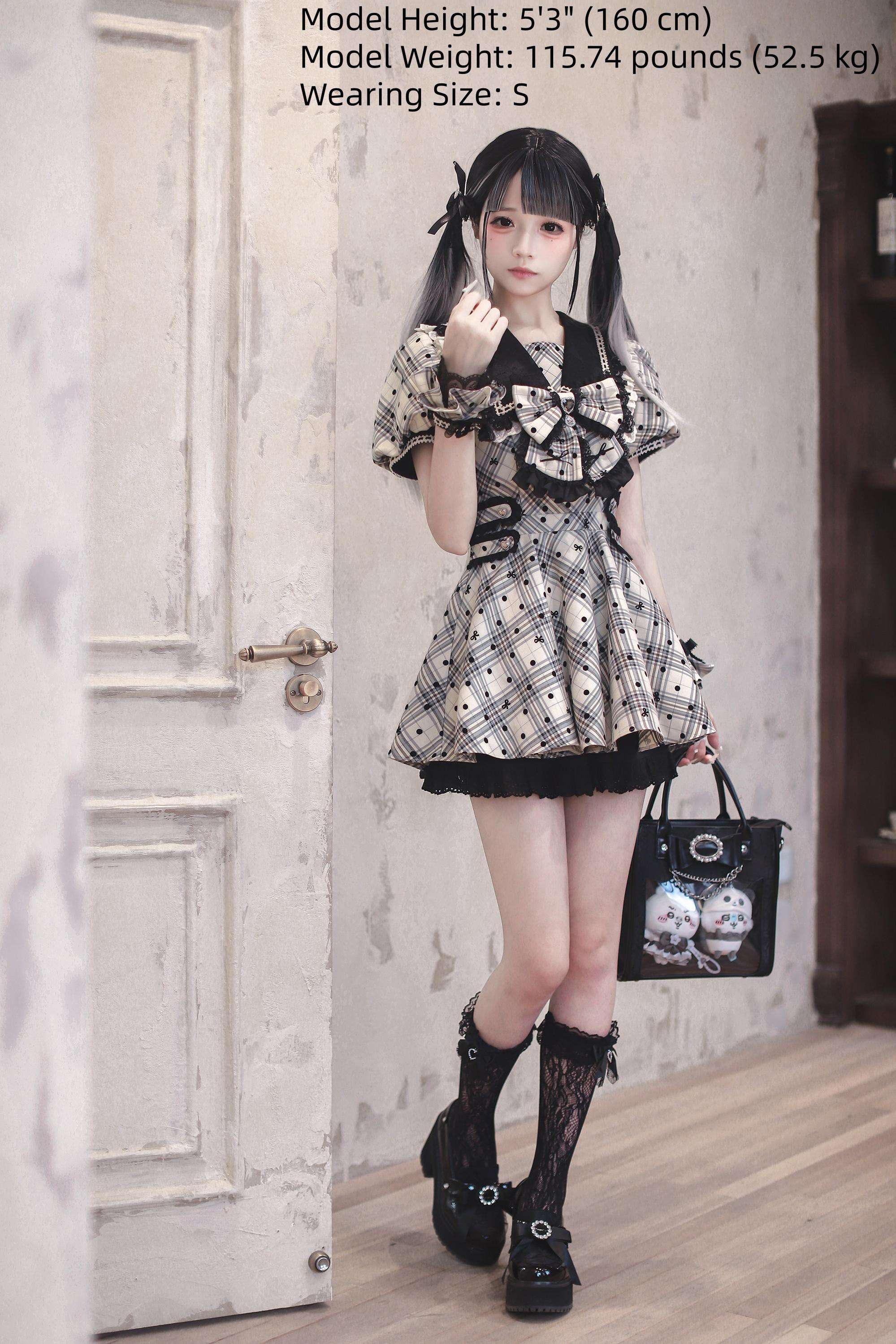 Front full-body standing view of Jirai Kei outfit in doorway showing matching wrist cuffs, black ruffled hem, and complete plaid polka dot ensemble with size reference text overlay