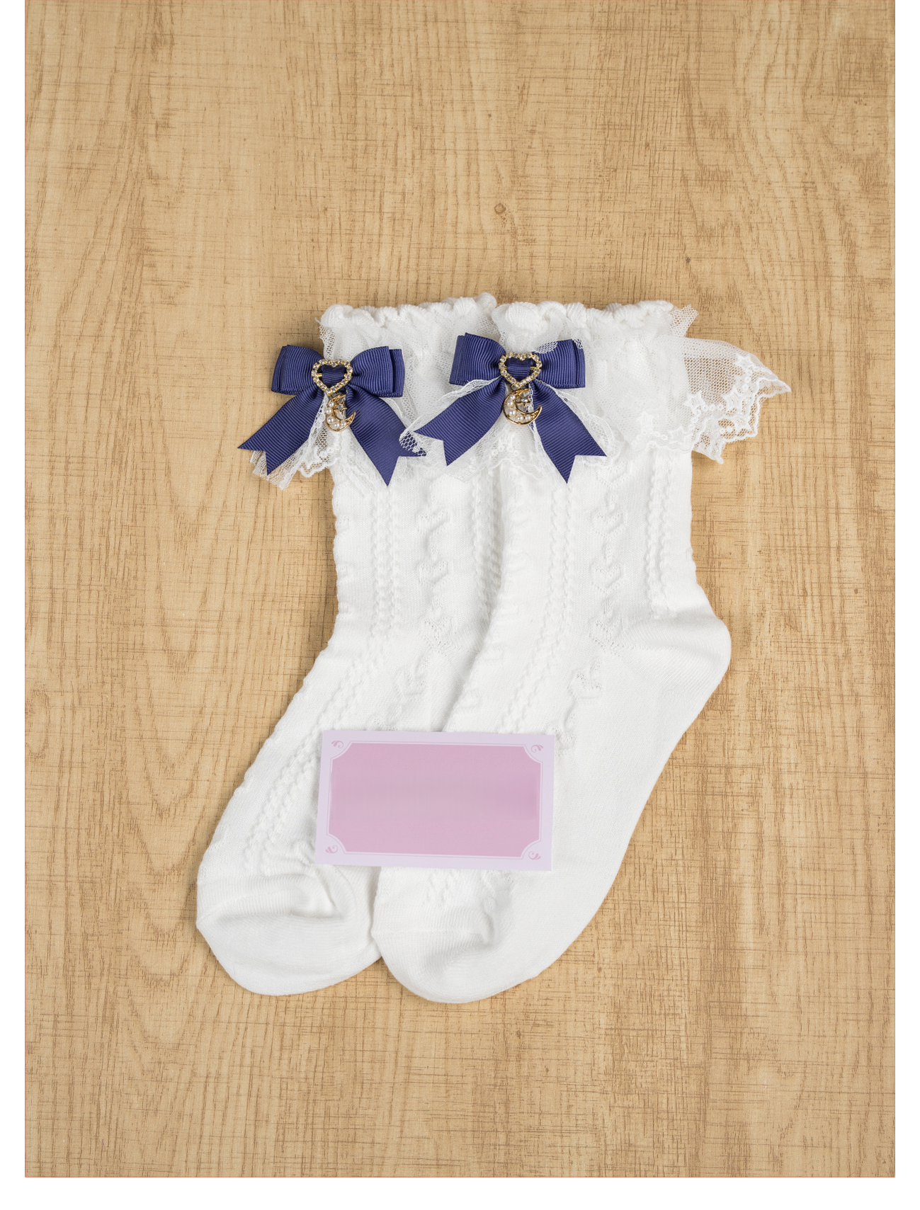 Navy blue Jirai Kei ankle socks with heart pendant moon charm, twisted knit white base fabric and ruffled lace ankle trim, flat lay