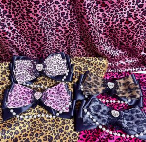 leopard print bow hair clips collection flat lay overhead view multiple color variants rose red brown grayish black leopard print heart rhinestone pearl chain satin edges