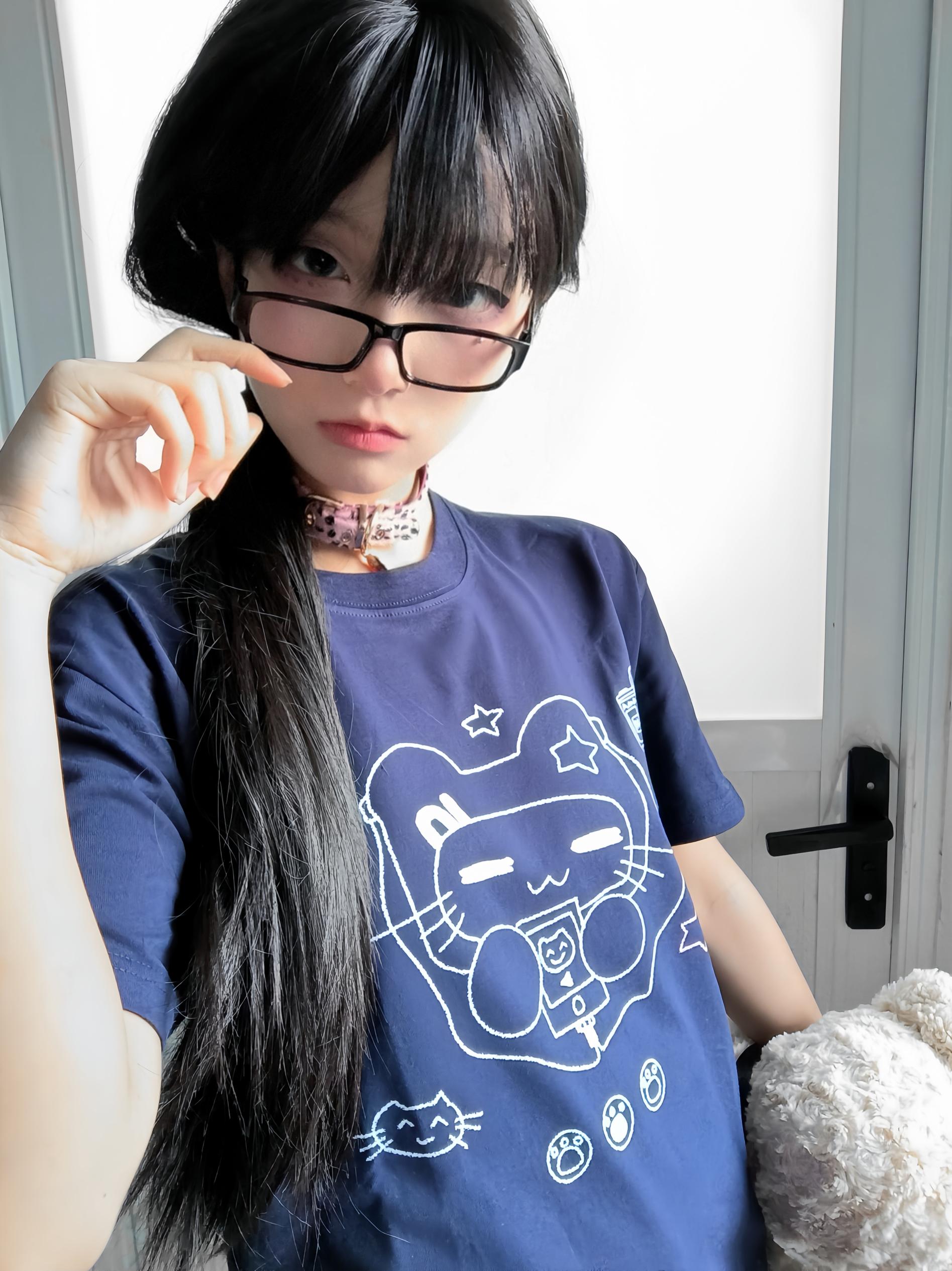 Model styling navy Jirai Kei cat headset graphic T-shirt with pink choker and eyeglasses in white door interior background