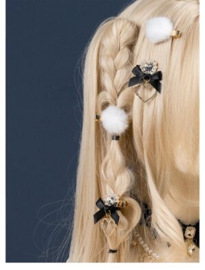 White pompom and black heart rhinestone bow hair clips worn on blonde braided doll hair jirai kei aesthetic lateral angle