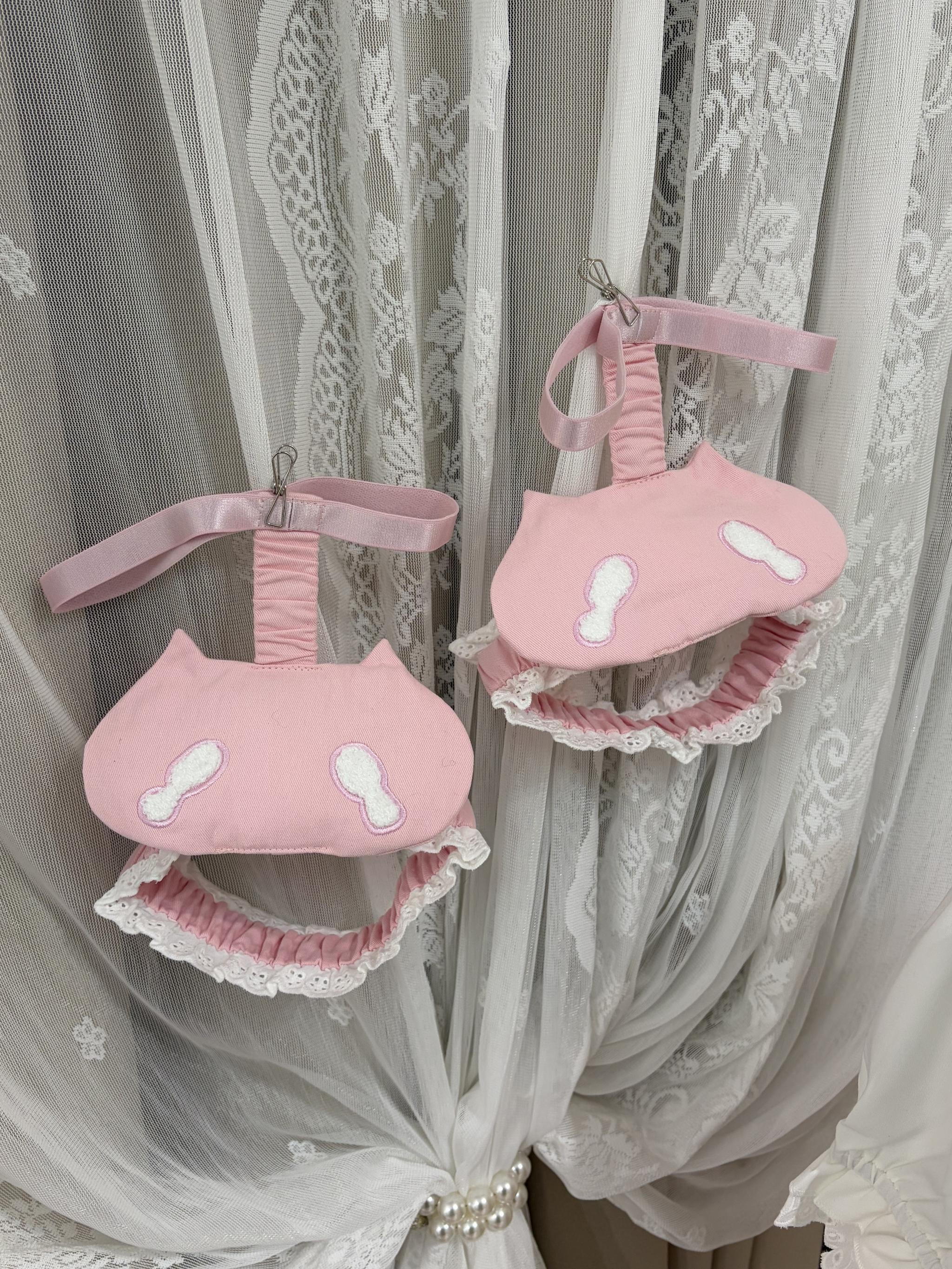 Kawaii cat-themed jirai kei fashion accessories and suspender dress decorations, pink lace trim elements with cute cat face patterns, flat lay detail shot