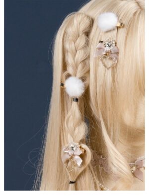 White pompom and white heart rhinestone bow hair clips displayed on blonde braided doll hair lateral rear view jirai kei style