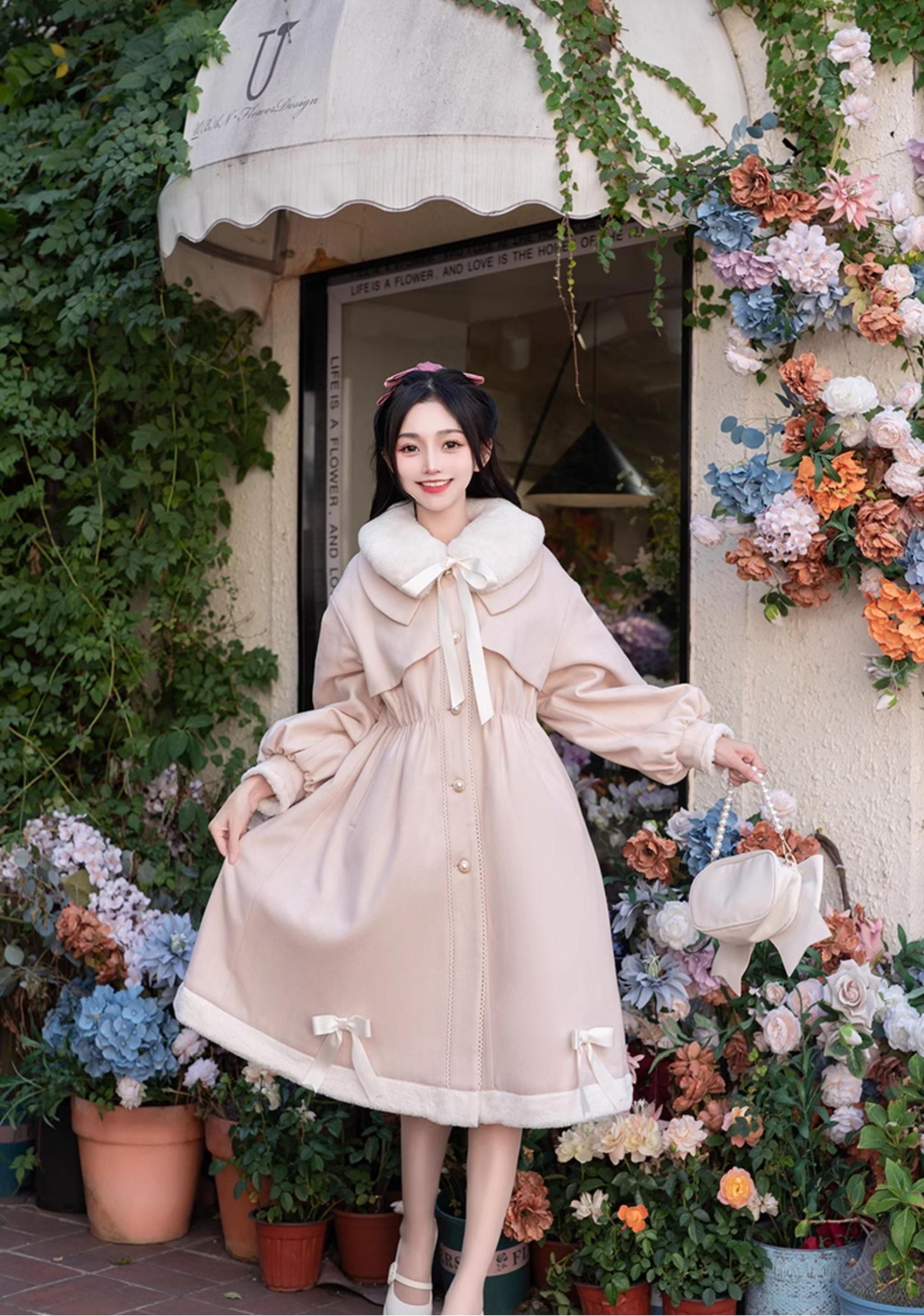 Light pink Ryousangata Jirai Kei winter coat back three-quarter view - female model carrying handbag wearing pink coat with button front, hem bow decorations, and relaxed waist fit