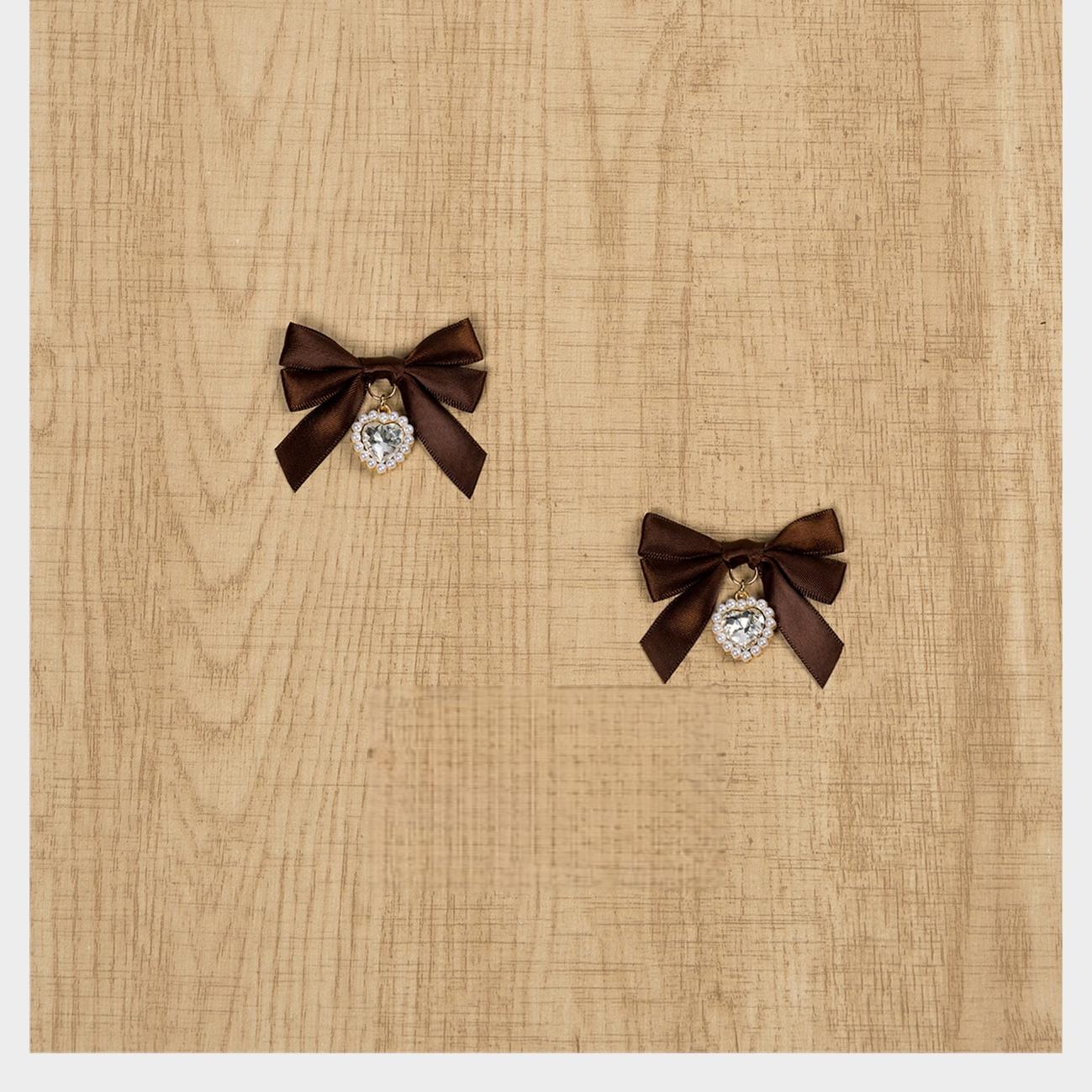 Dark brown satin Jirai Kei bow hair clips featuring round rhinestone pendant charms on wooden table flatlay photography