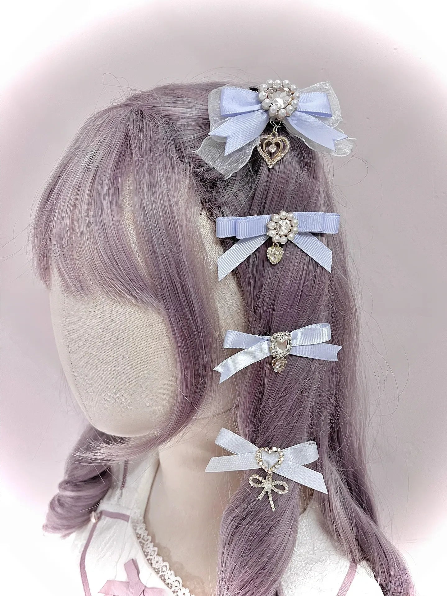 Water blue light blue satin bow hair clips with rhinestone embellishments and heart pendant accents on mannequin front left view angle Jirai Kei style