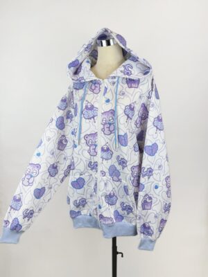 White yami kawaii hooded jacket with purple cartoon bear and cupcake prints, light blue ribbed trims, front view displayed on mannequin