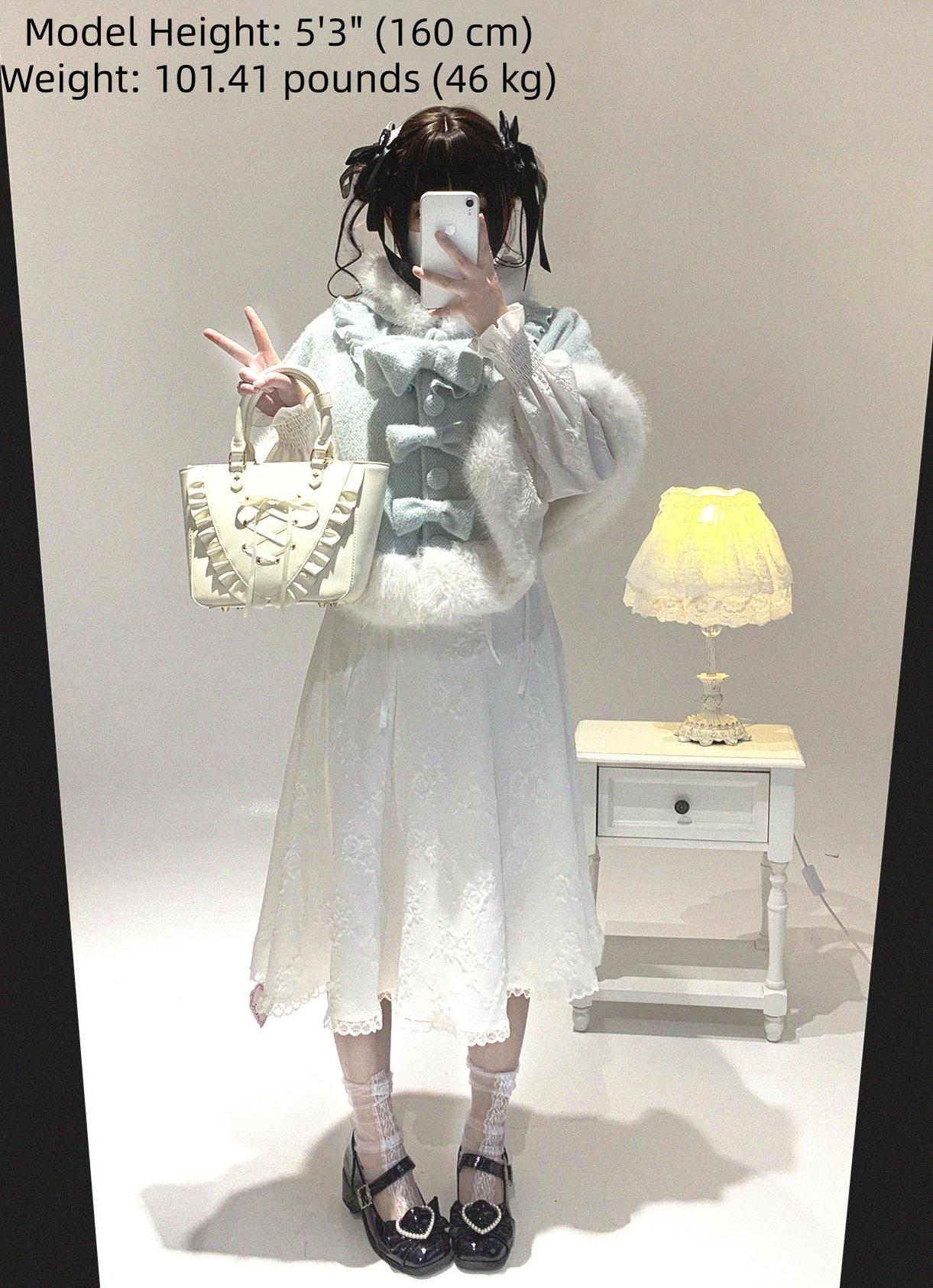 Model in white lace dress with light blue cat-ear cape featuring white fuzzy trim and measurement reference label for Jirai Kei fashion sizing