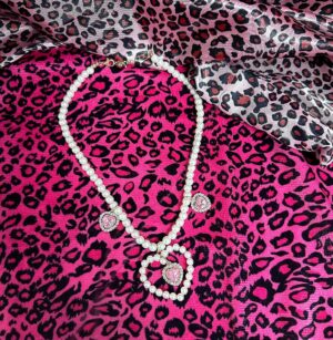 Simple jirai kei pearl Y-necklace with heart rhinestone pendants and pink gem accents minimalist style flat lay