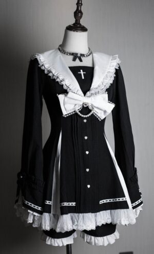 Black and white striped Jirai Kei hime dress with cross accents and delicate lace trim on dress form, showcasing sailor collar and ruffled hem details for dark romantic aesthetic