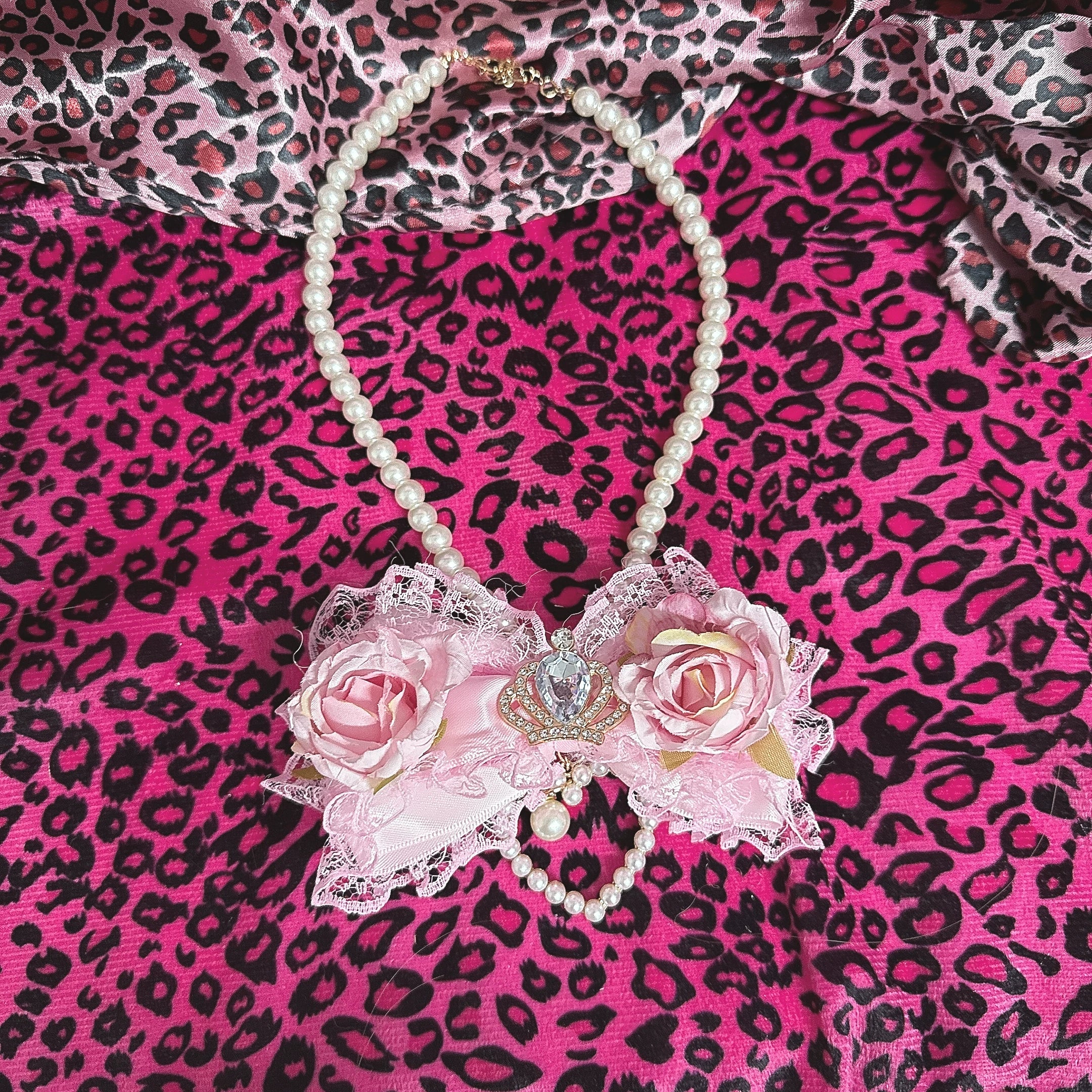 Jirai Kei light pink floral bow pearl necklace flat lay soft rose lace with crystal rhinestone center accent
