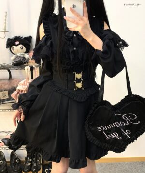 Black ruffled pleated Jirai Kei suspender skirt with heart-shaped metal buckle waistband styled with black heart-shaped handbag in doll-themed interior aesthetic