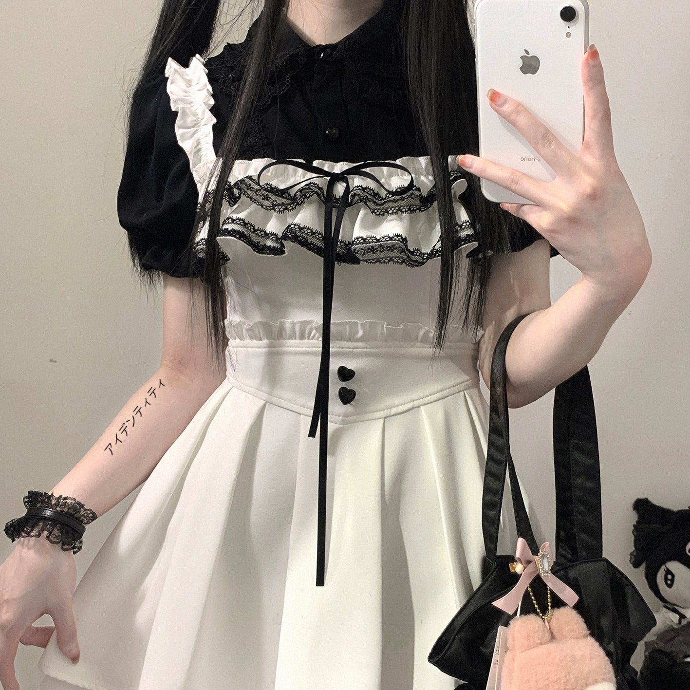 Black and white Jirai Kei chiffon blouse with delicate lace bust trim and drawstring tie, paired with high-waist skirt, close-up mirror selfie with wrist tattoo