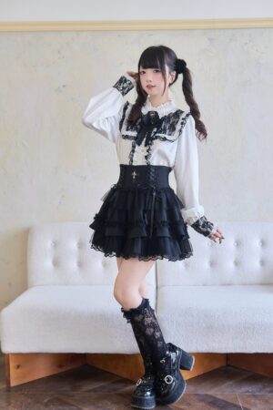 Two-tone Jirai Kei outfit featuring white blouse with black ruffle trim, thigh-high lace socks, and black layered mini skirt full-body styling