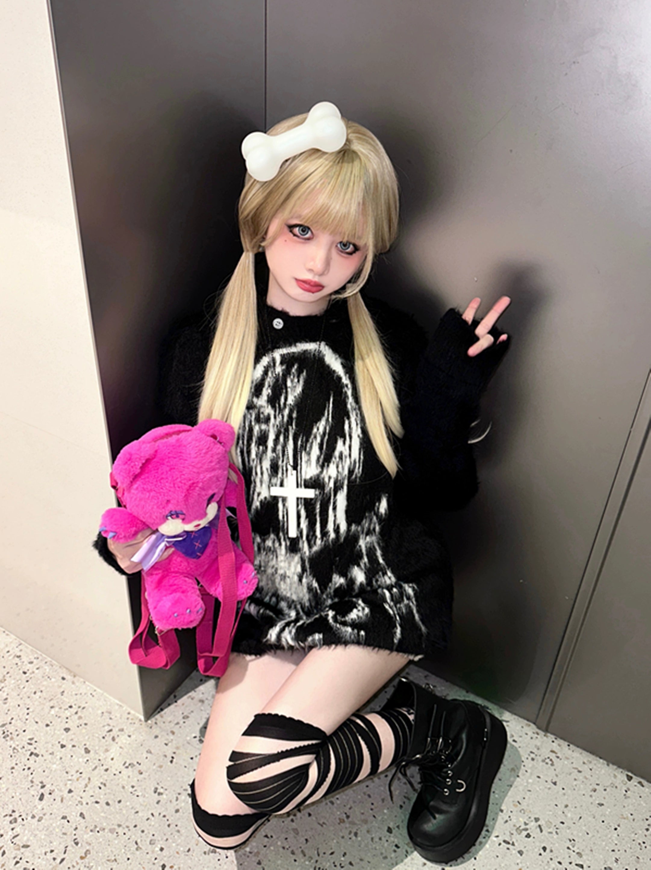Black fuzzy hooded sweater worn as mini dress jirai kei styling with bone hair accessory striped socks platform boots indoor hallway