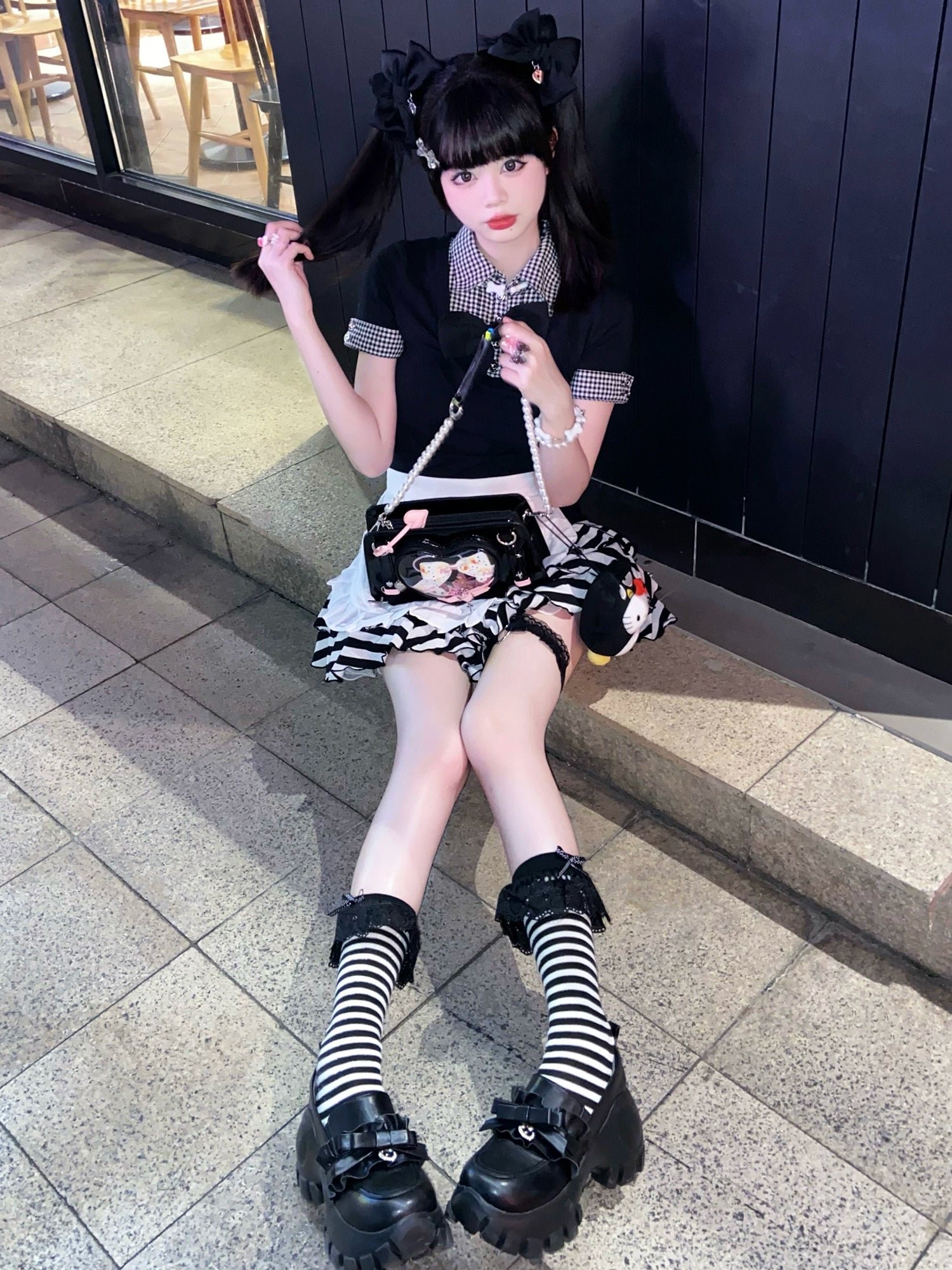 Full-body outdoor portrait of JK platform shoes with chunky black lug sole, paired with striped socks and gothic outfit on mall stairway