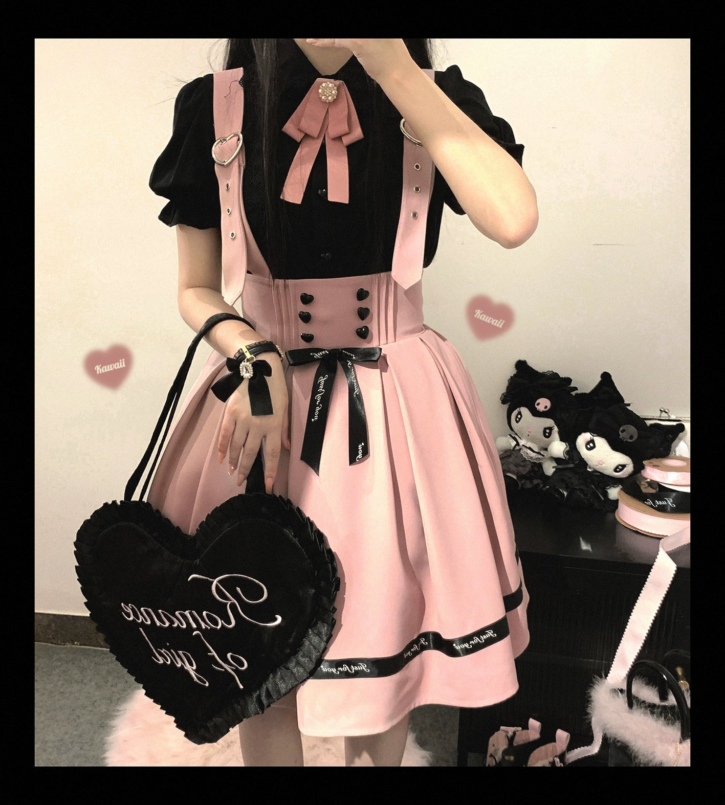 Pink and black Jirai Kei lolita blouse outfit with pink suspender skirt, satin bow accent, and heart-shaped tote bag, mirror selfie front view