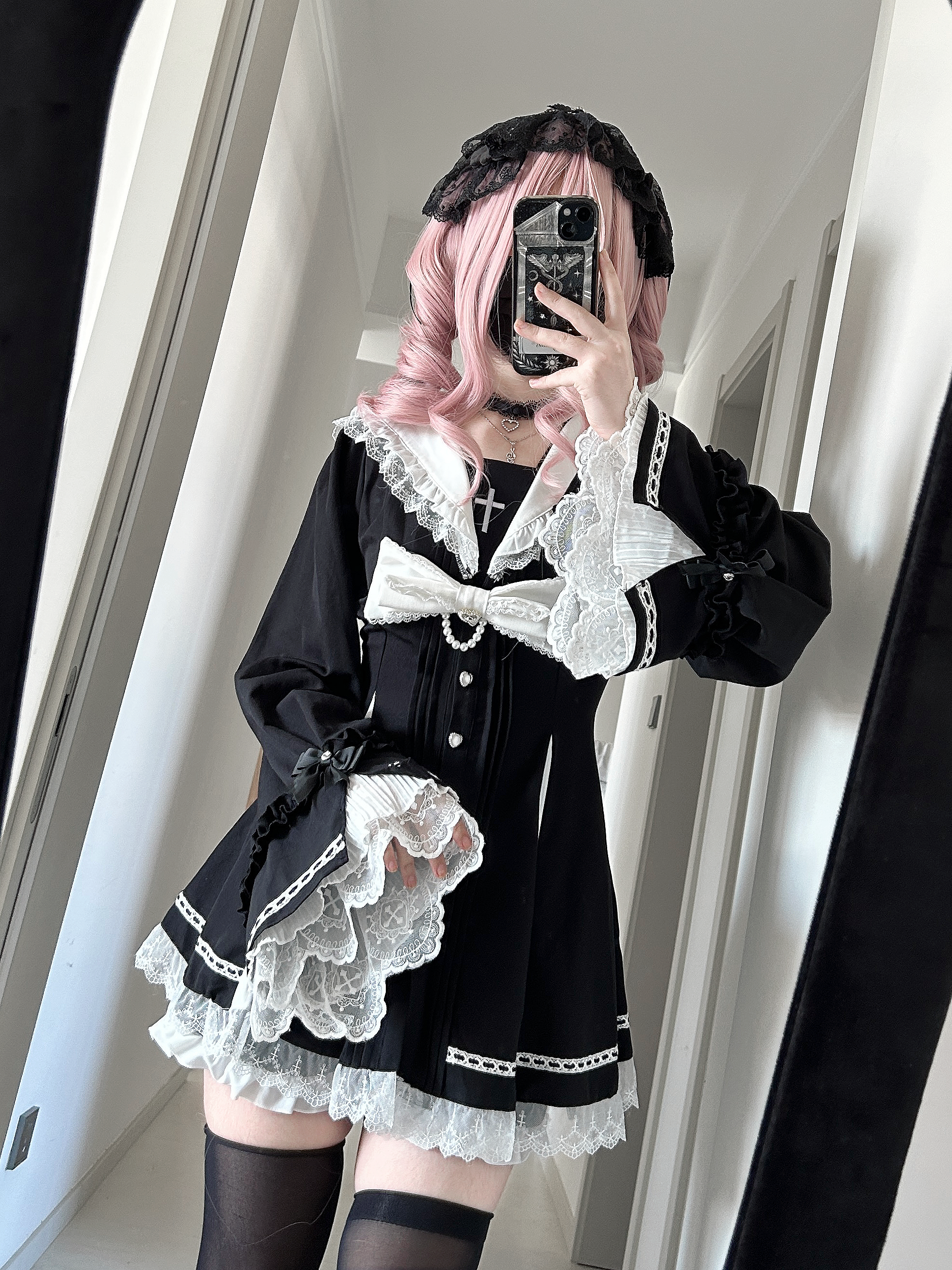 Close-up mirror selfie of Jirai Kei black and white gothic hime dress featuring detachable lace cuffs, delicate lace dress hem, and intricate lace-up back corset styling detail