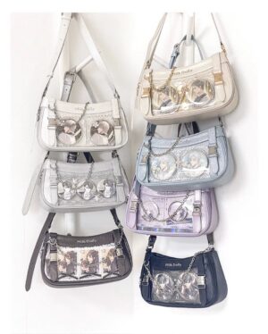 Flat lay overhead view of multiple Y2K Jirai Kei ita bags in various holographic colors including diamond silver, obsidian black, aqua blue, violet, and champagne with clear display windows and detachable metal chains