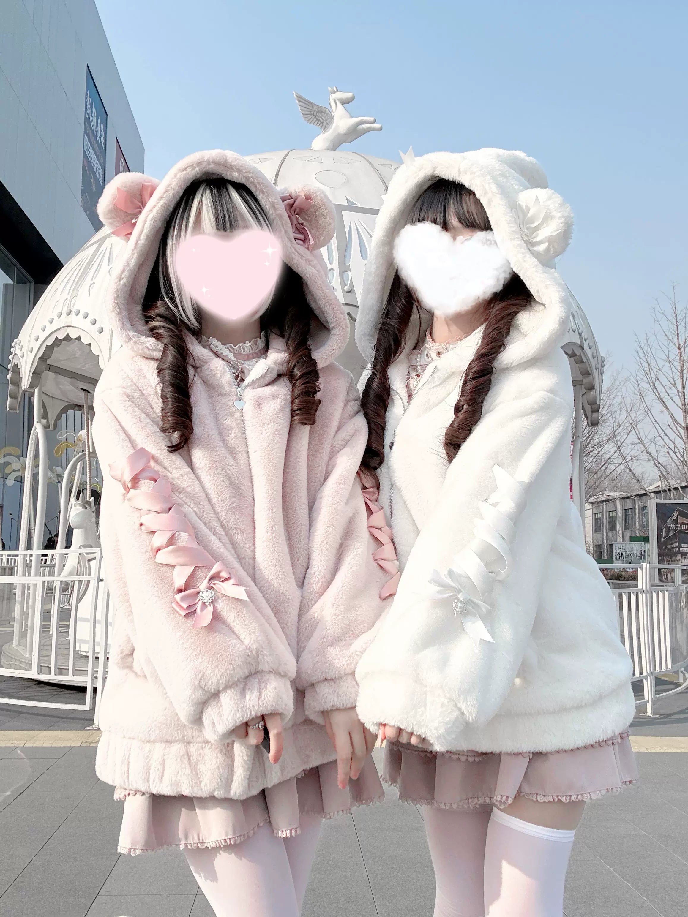 Front view of Ryousangata bear ear hoodie plush winter coat in pink and off-white variants on two models wearing lolita fashion outdoors