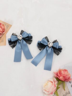 blue jirai kei bow hair clip with black lace overlay round rhinestone center long ribbon tails overhead view