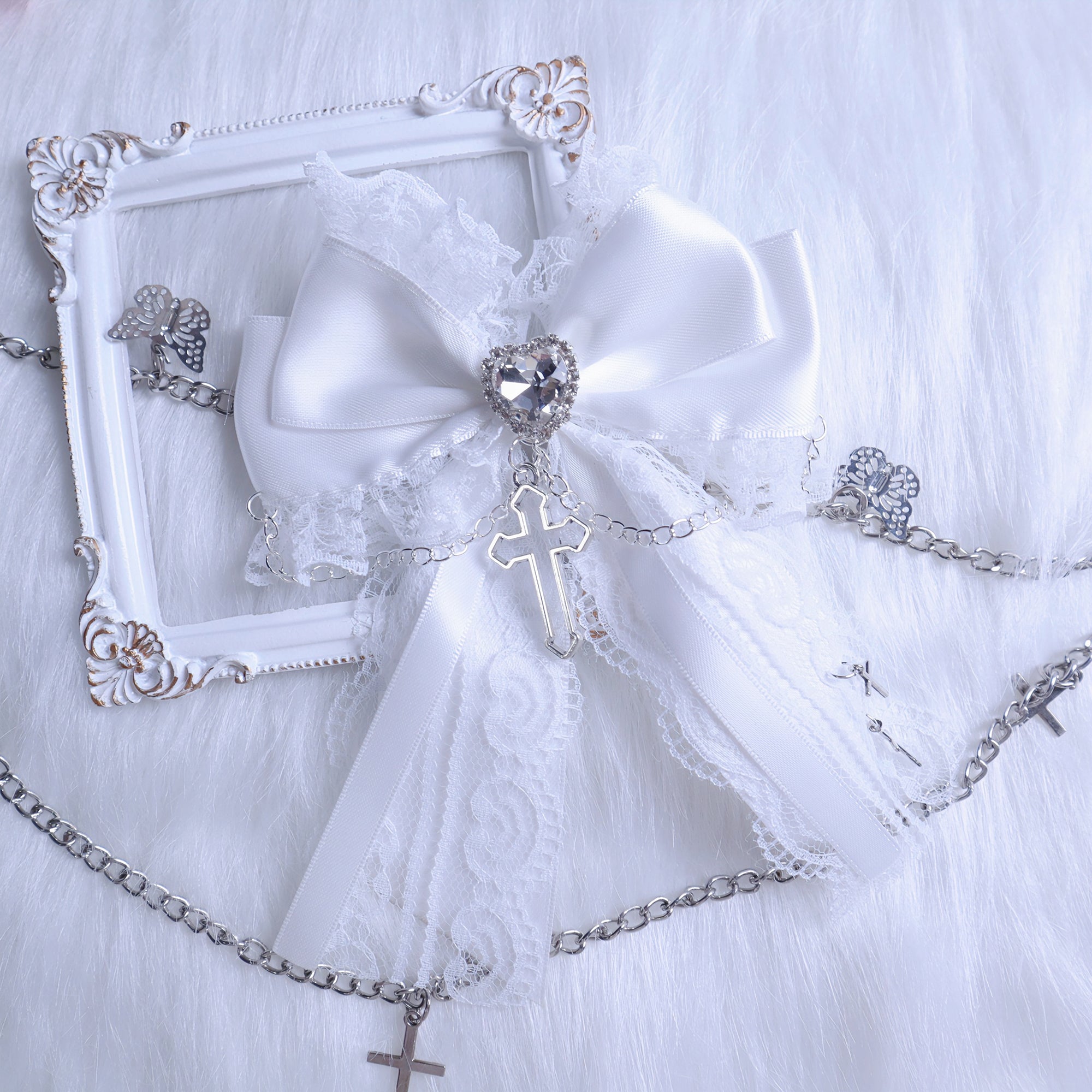 White satin bow lace trim hair clip displayed with vintage decorative frame showing heart rhinestone and silver cross charm metal chain accessories