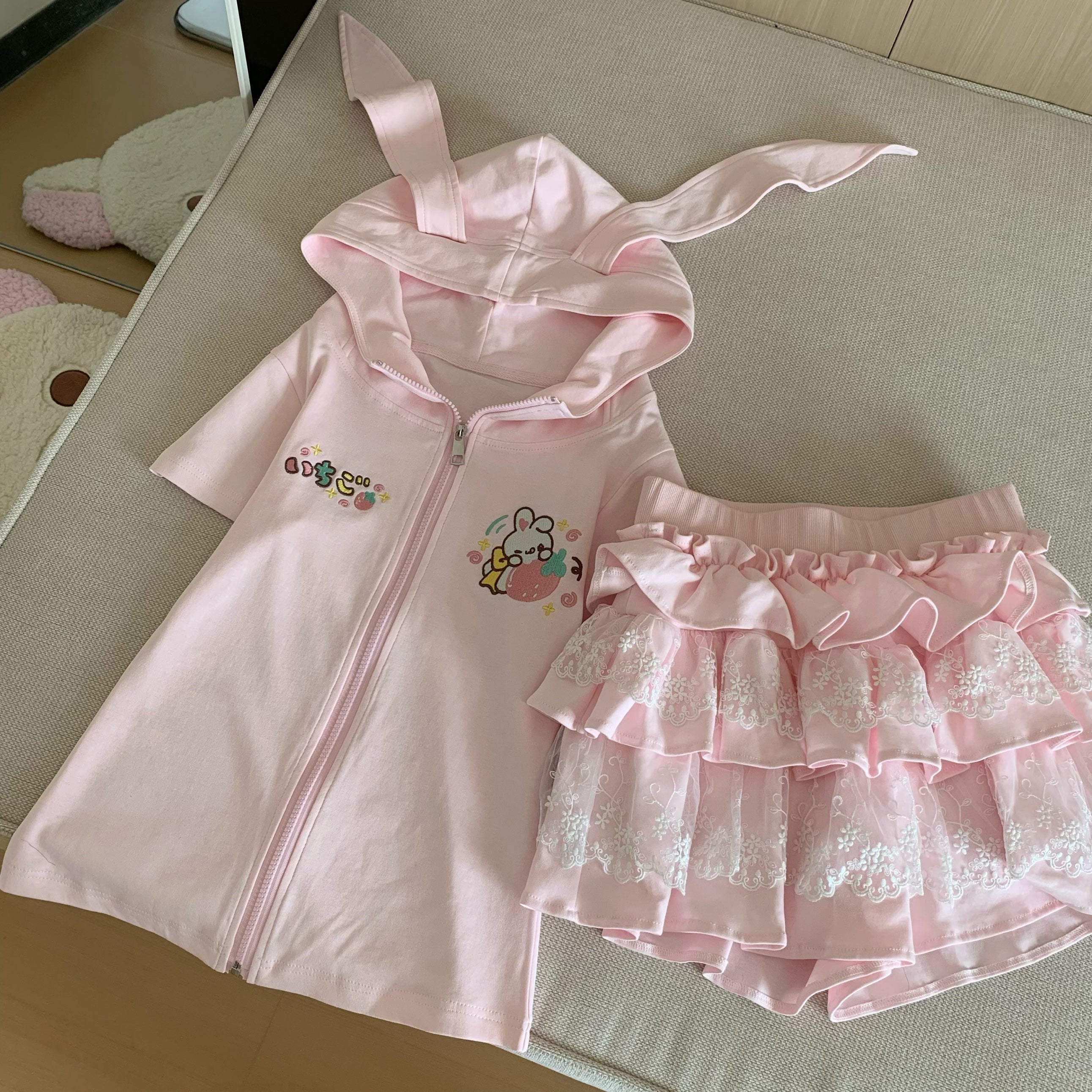 Separated pink bunny-ear hoodie and ruffle skirt showing individual pieces of Jirai Kei coordinate for styling versatility