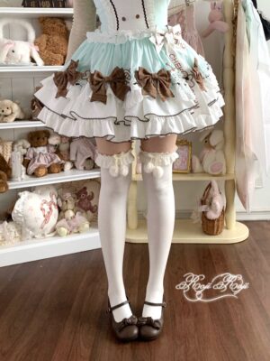 Ivory combed cotton Lolita over-the-knee socks featuring brown ruffled bow embellishments, styled with brown Mary Jane footwear and coordinating brown-mint Lolita dress, front-facing aesthetic display