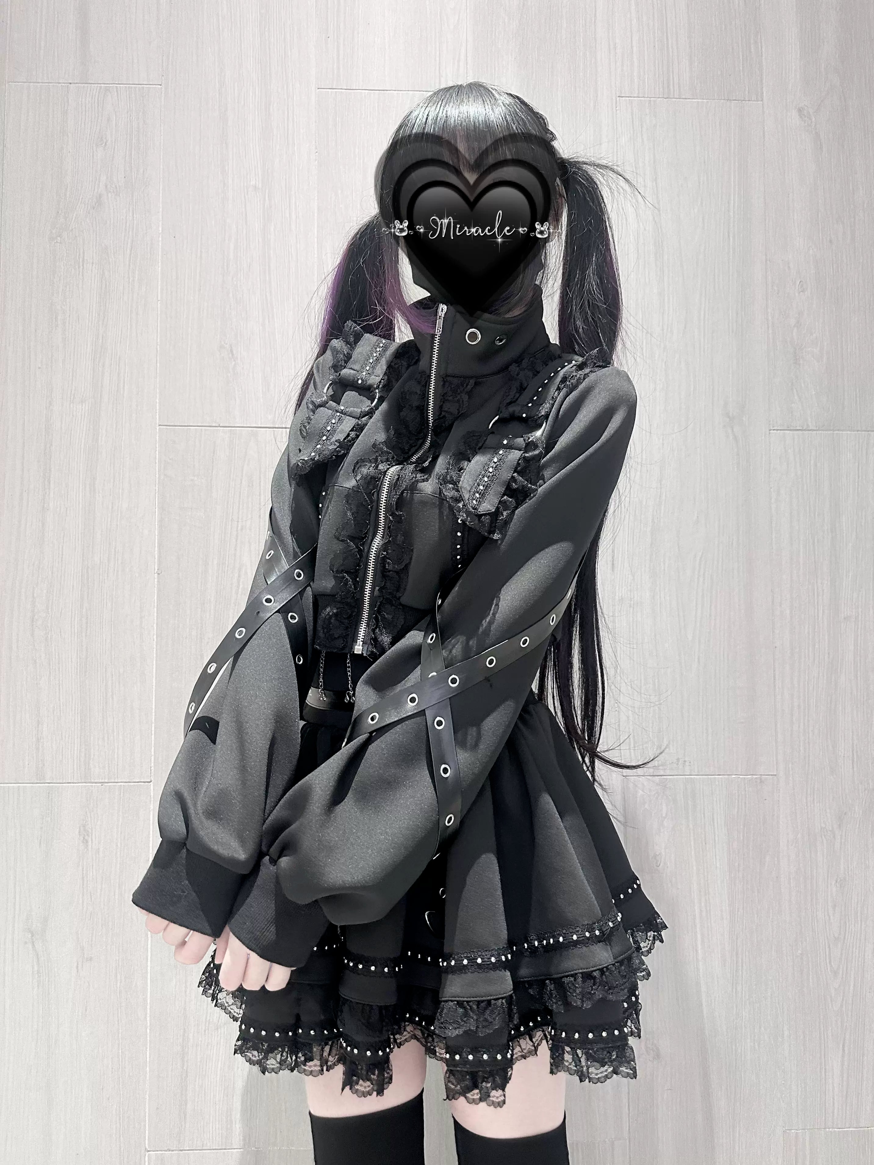 Dark Jirai Kei outfit set side three-quarter view showing jacket loose sleeves lace ruffle skirt hem shoulder strap decorations wooden wall