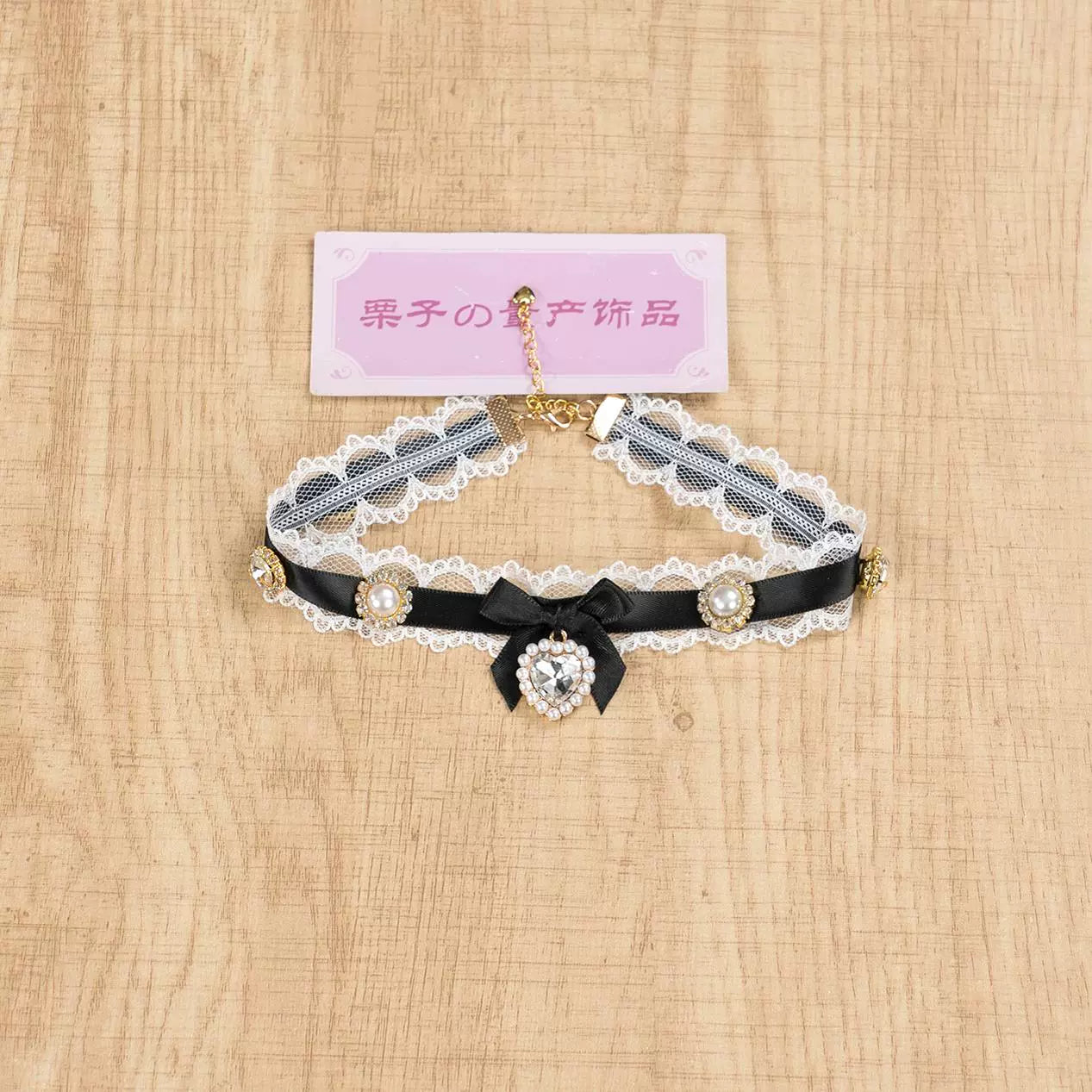 Black and white lace Jirai Kei choker necklace with contrasting black satin bow and central heart rhinestone pendant