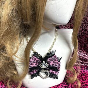 Pink leopard pearl choker necklace with crown rhinestone and pearl heart pendant on blonde wig mannequin close-up front view Jirai Kei style