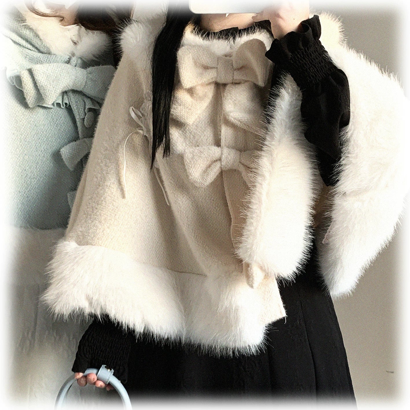 Linen-color cat-ear hooded cape modeled on figure, showcasing neutral tone option with white fuzzy trim and button fastener system